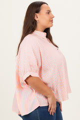 woman wearing a pink and white striped plus size button-up blouse with short sleeves and a relaxed fit