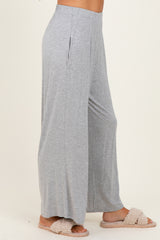 woman wearing light gray wide leg lounge pants with side pockets and fluffy slippers