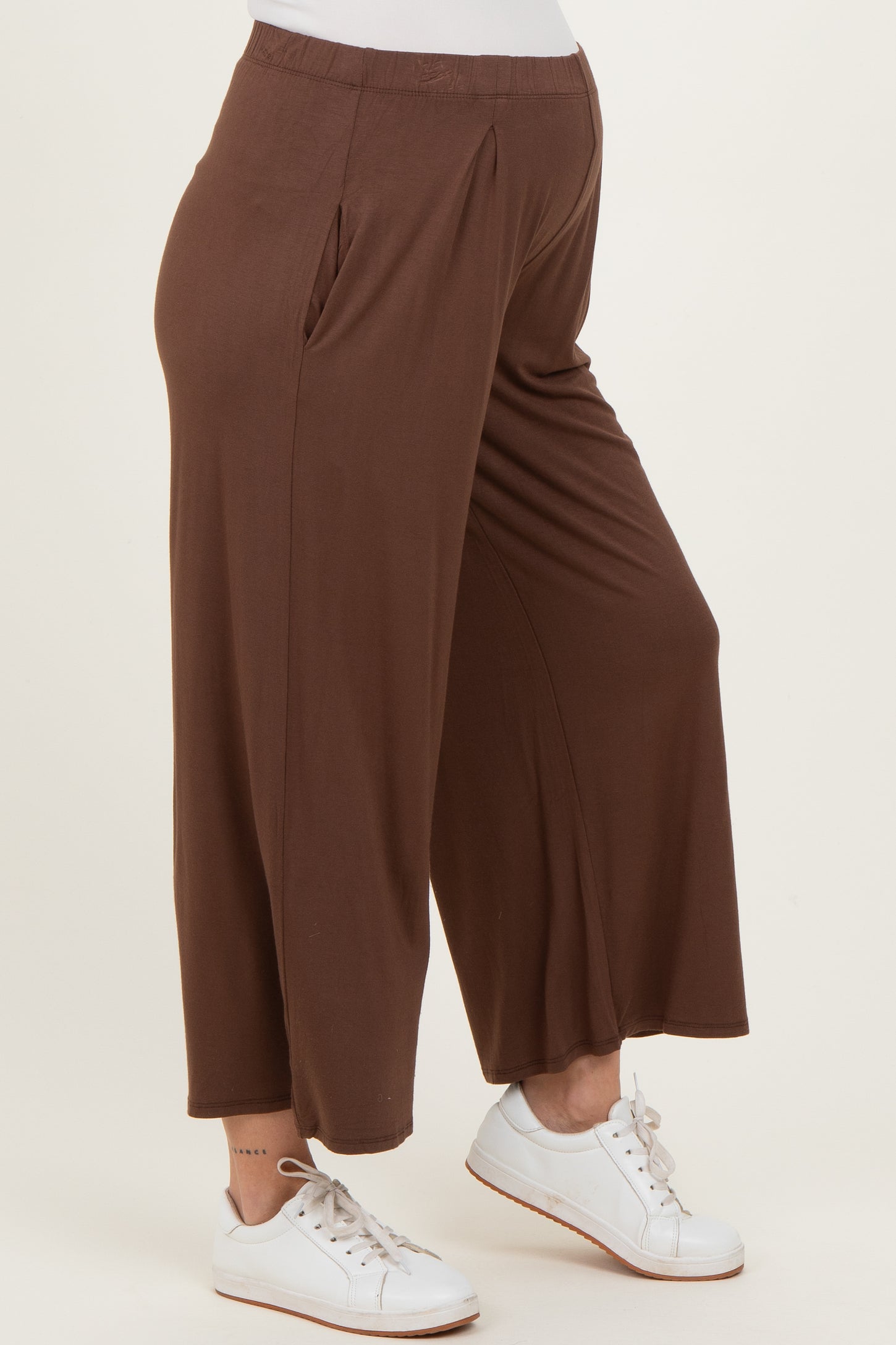 woman wearing brown maternity wide-leg pants with side pockets and a comfortable fit