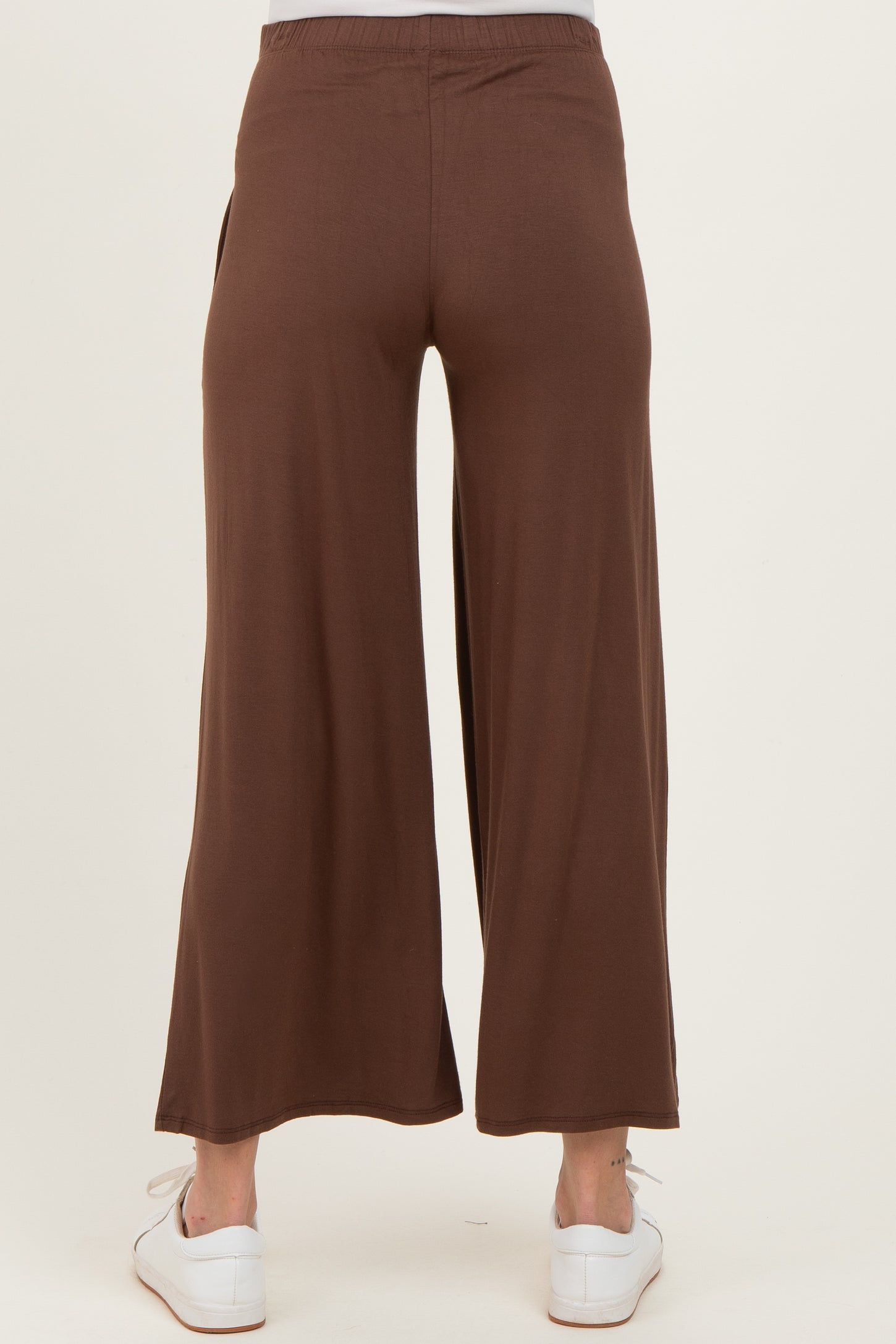 maternity wear brown wide-leg pants viewed from the back, styled with white sneakers