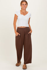 woman wearing a white short sleeve crop top and brown wide-leg pants with pockets