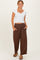 woman wearing a white short sleeve crop top and brown wide-leg pants with pockets