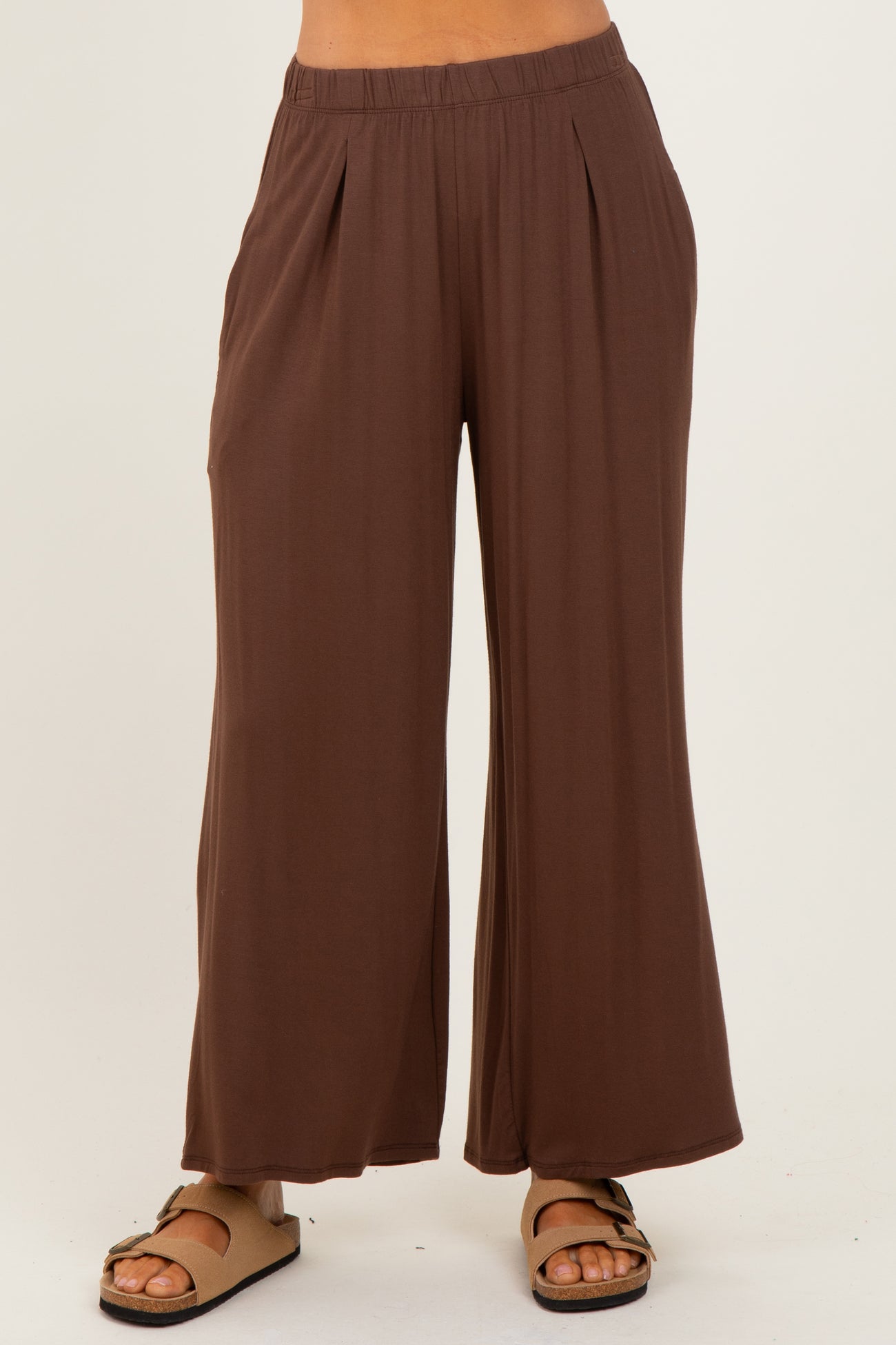 woman wearing brown wide-leg palazzo pants with an elastic waistband and side pockets