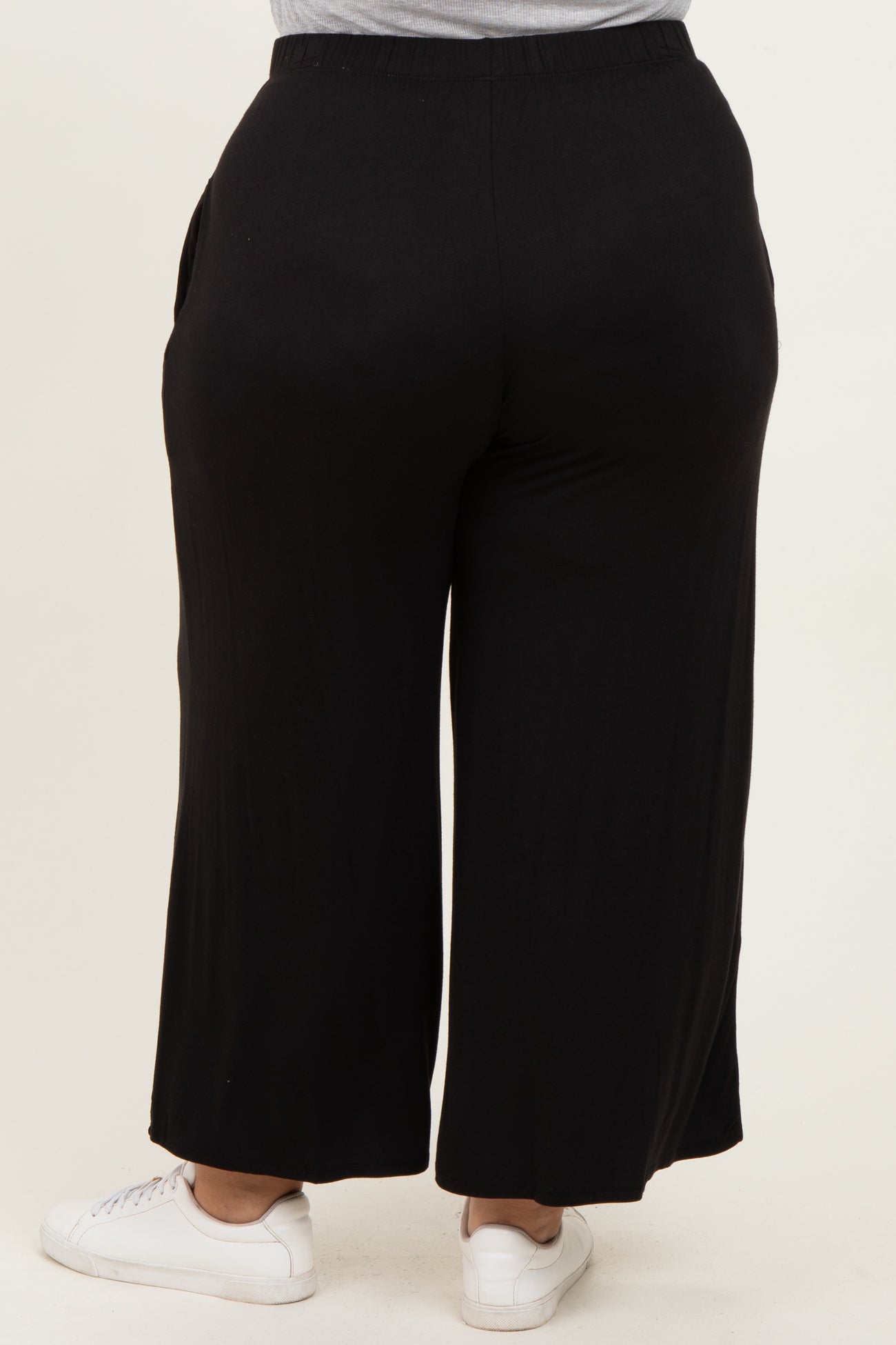 woman wearing black wide-leg plus size pants with elastic waistband, viewed from the back