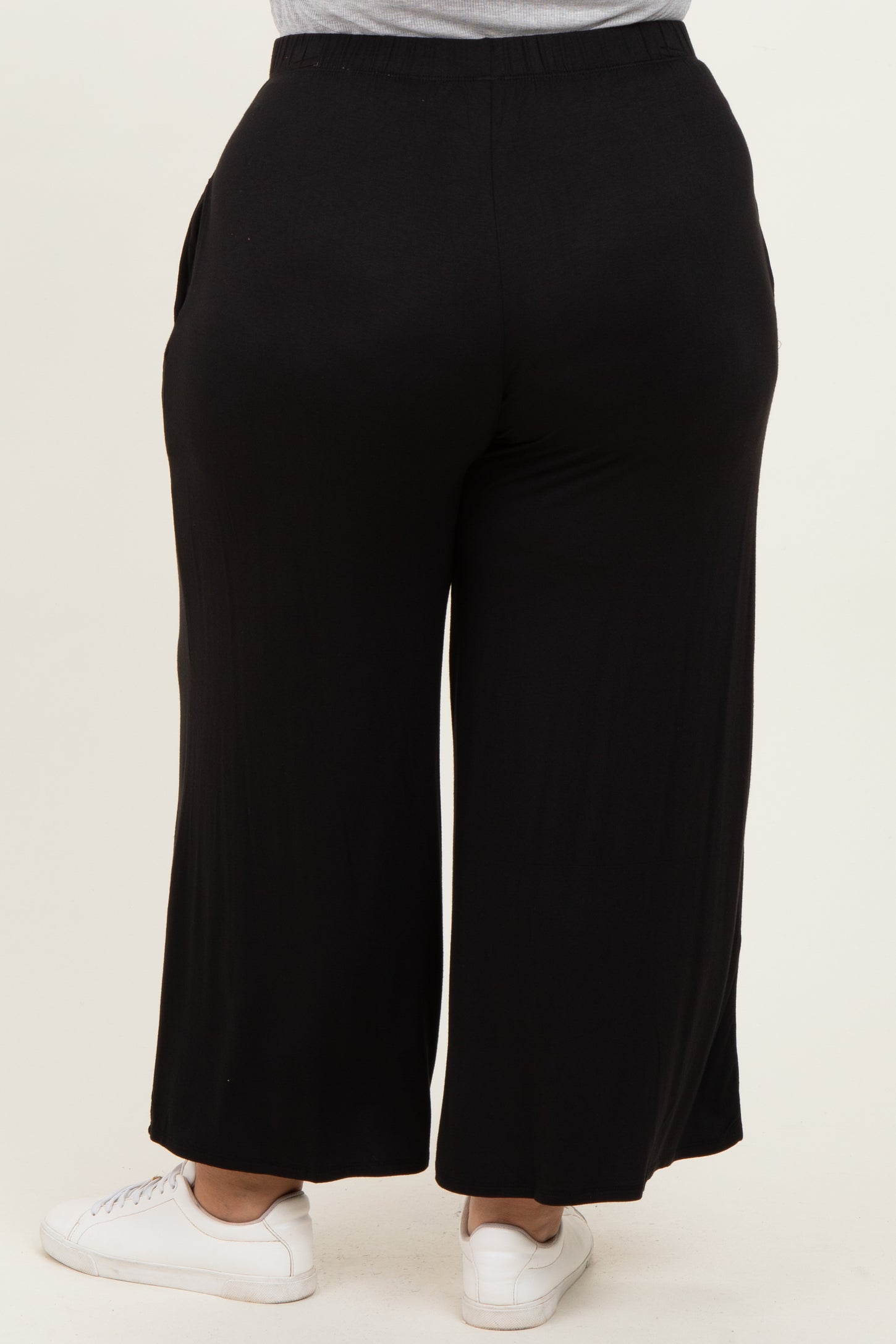 woman wearing black wide-leg plus size pants with elastic waistband, viewed from the back