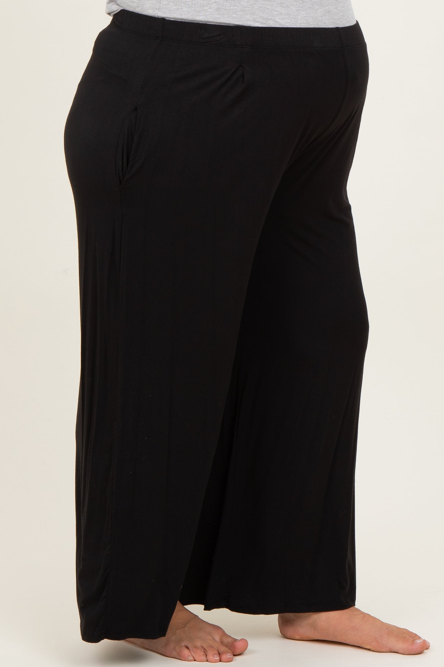 woman wearing black maternity plus wide-leg pants with a comfortable fit and side pockets