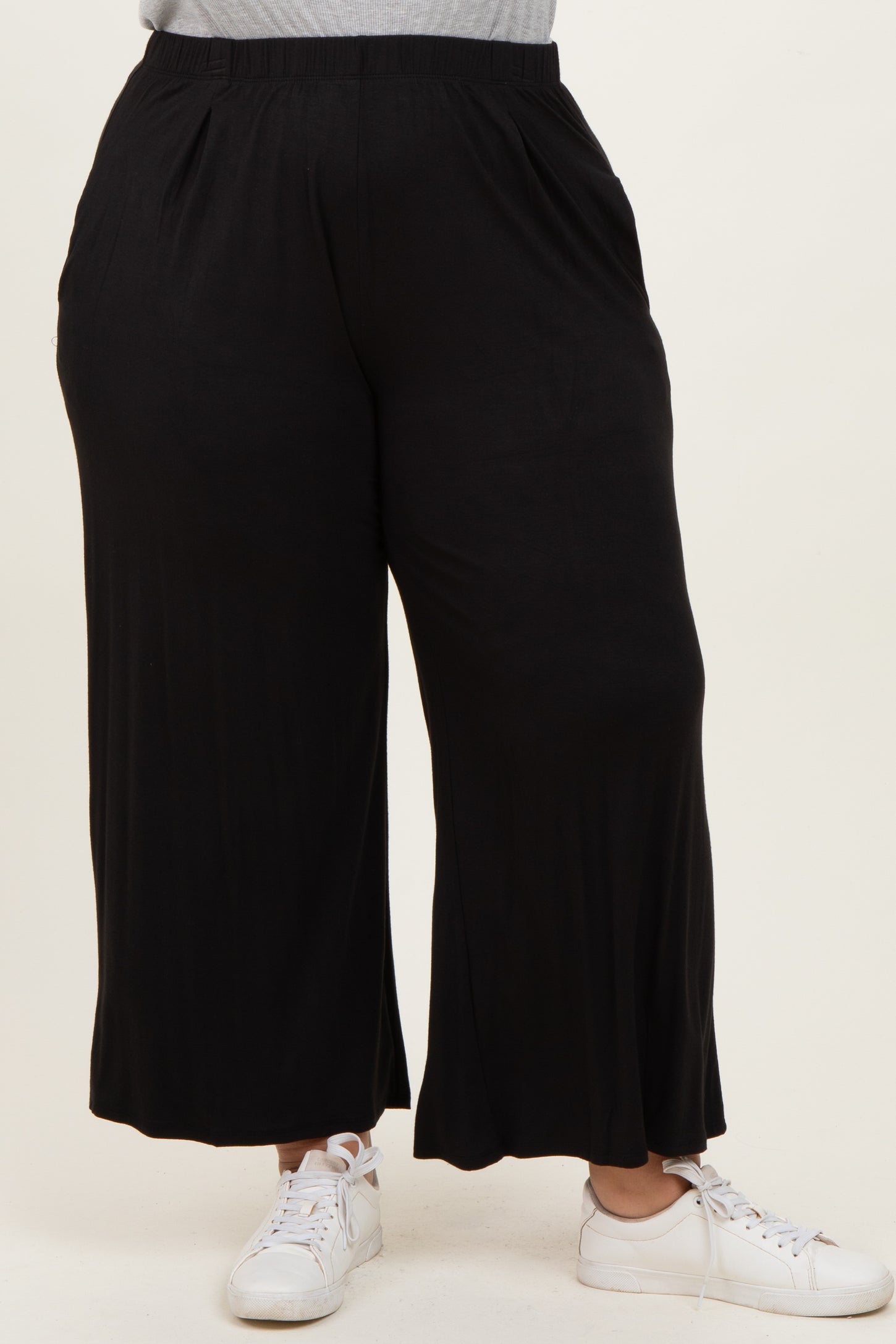 woman wearing black wide-leg plus-size pants with an elastic waistband and side pockets