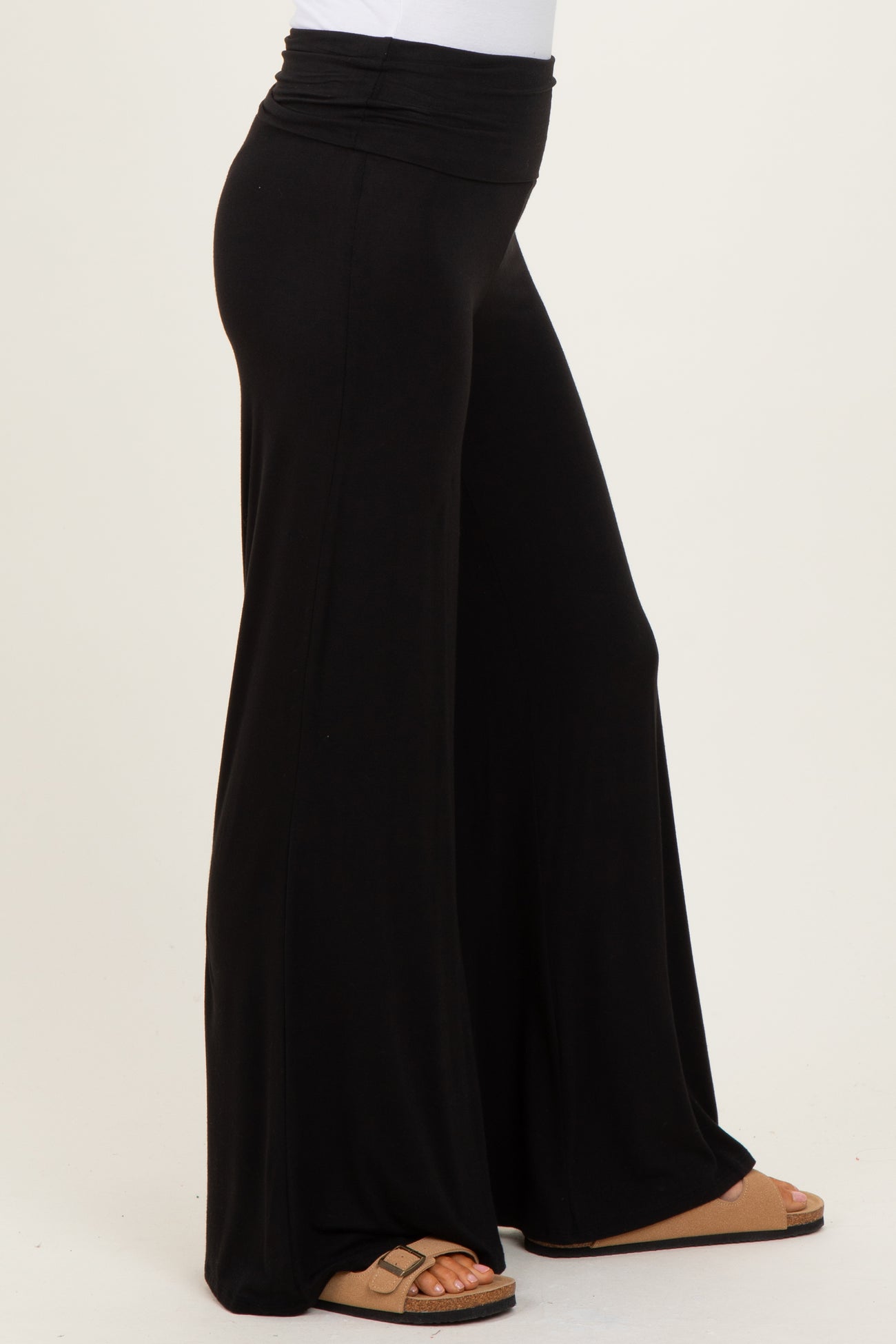 woman wearing black wide-leg lounge pants with a high waistband and sandals