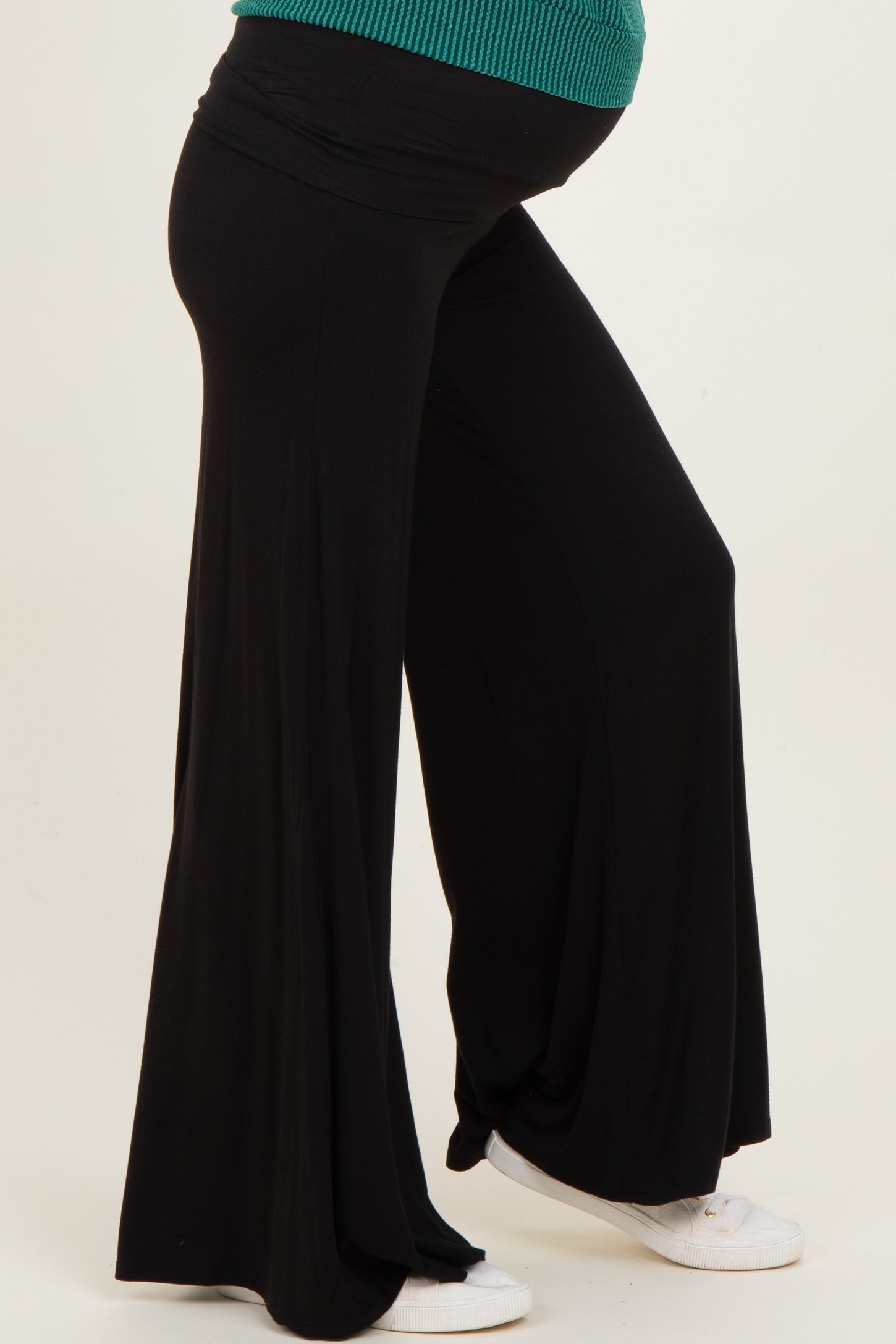 woman wearing a black maternity pant with a flowing silhouette and a visible baby bump