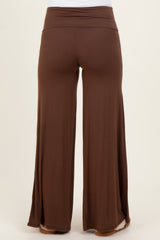 woman wearing brown maternity wide leg pants with a comfortable high waistband and side slits at the hem