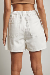 woman wearing white high-waisted denim shorts with an elastic waistband and back pockets