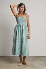 woman wearing a teal and white striped midi dress with smocked bodice and tie straps