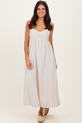 woman wearing a light beige strapless maxi dress with a gathered bodice and a relaxed fit