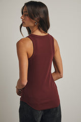 woman wearing a burgundy sleeveless ribbed tank top from the back, styled with dark pants