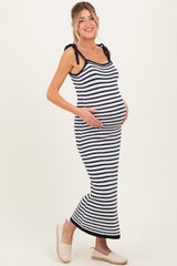 woman wearing a navy and white striped maternity maxi dress with tie straps and holding her baby bump