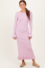 woman wearing a light pink ribbed long sleeve dress with bell sleeves and ruffle hem