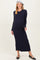 woman wearing a navy ribbed maternity maxi dress and a beret, showcasing her baby bump