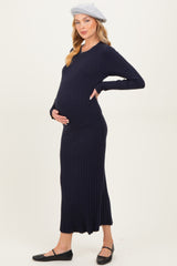 woman wearing a navy blue ribbed maternity dress and holding her baby bump