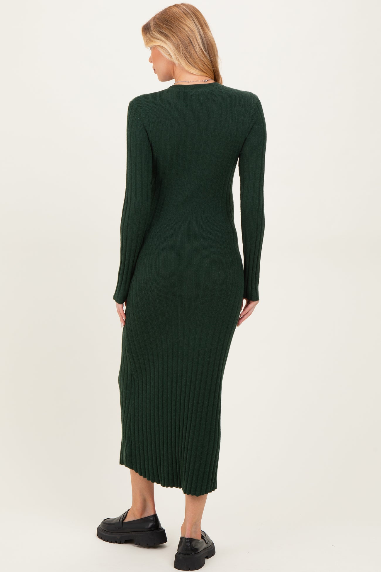 woman wearing a dark green ribbed midi maternity dress, showing a form-fitting silhouette from the back