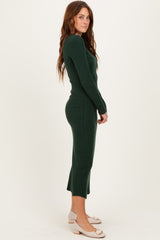 woman wearing a forest green ribbed midi dress with long sleeves and a fitted silhouette