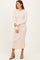 woman wearing a light pink long sleeve ribbed midi dress and tan ankle boots