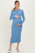 woman wearing a light blue ribbed maternity dress and holding her baby bump