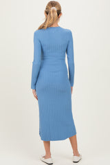 woman wearing a fitted ribbed baby blue maternity dress with long sleeves and a midi length, showing a baby bump