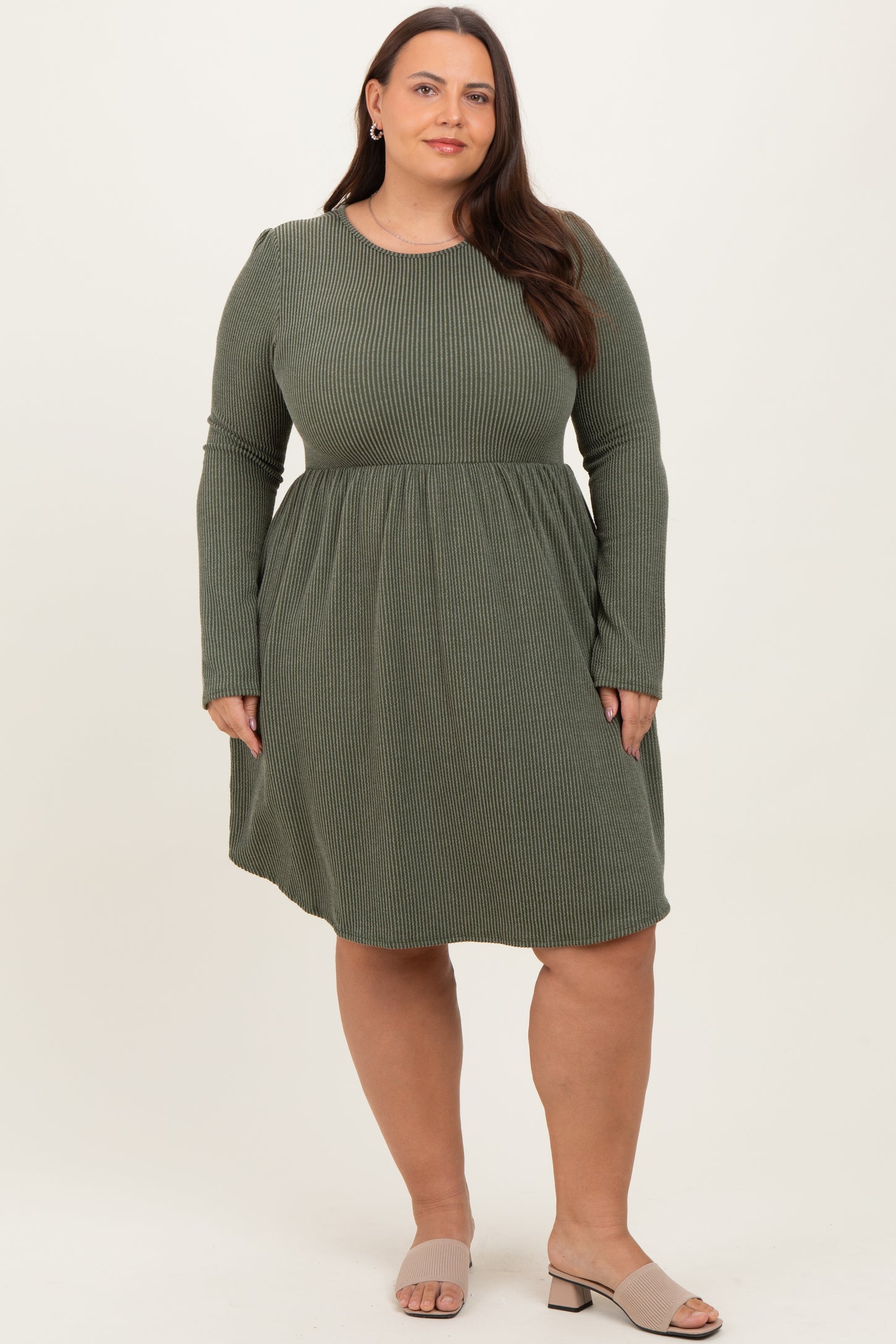 woman wearing a long sleeve olive green striped plus size dress with a flared skirt and a rounded neckline