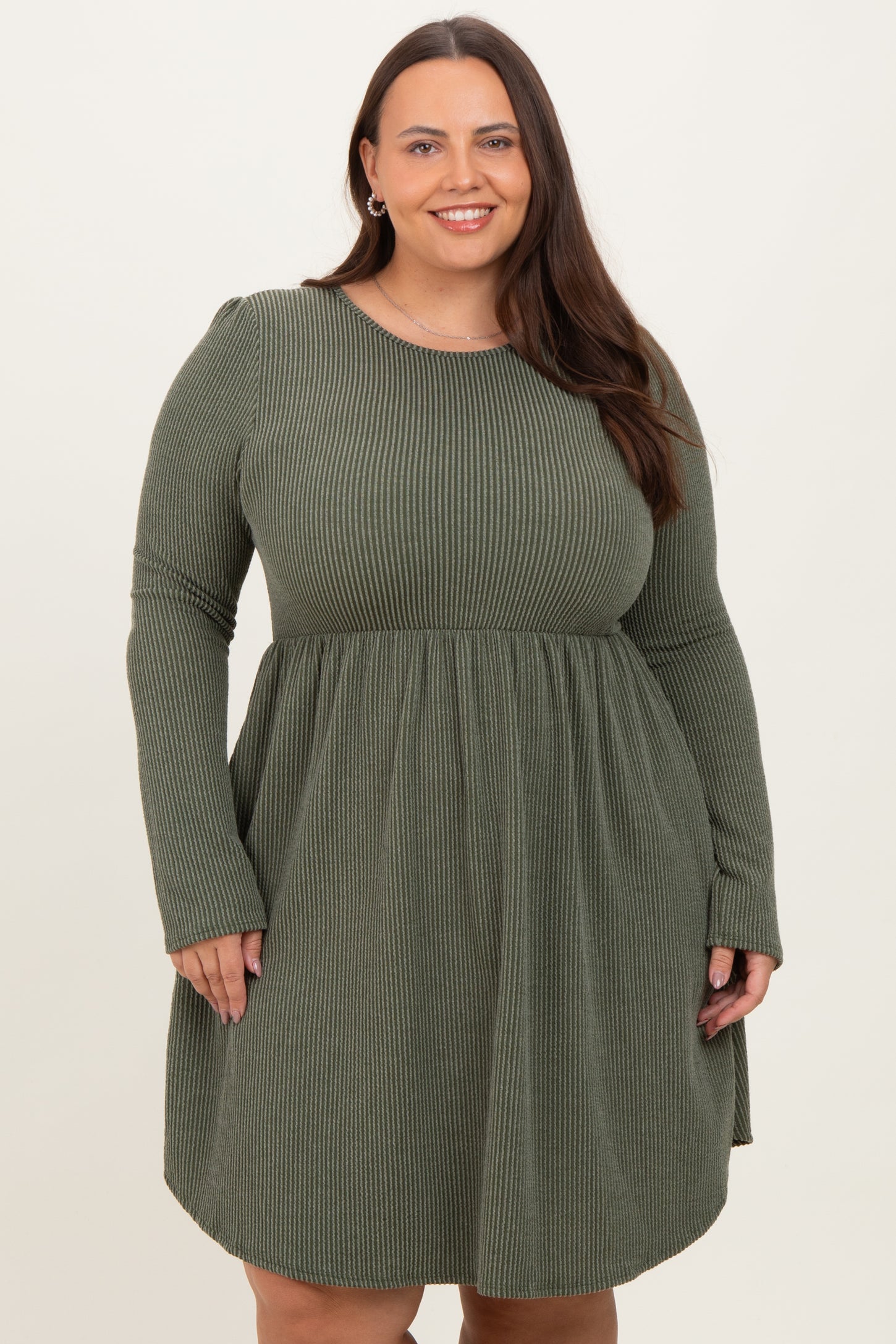 woman wearing a dark green long sleeve ribbed dress with a fitted bodice and flowy skirt