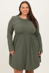 woman wearing a dark green long sleeve ribbed dress with a fitted bodice and flowy skirt
