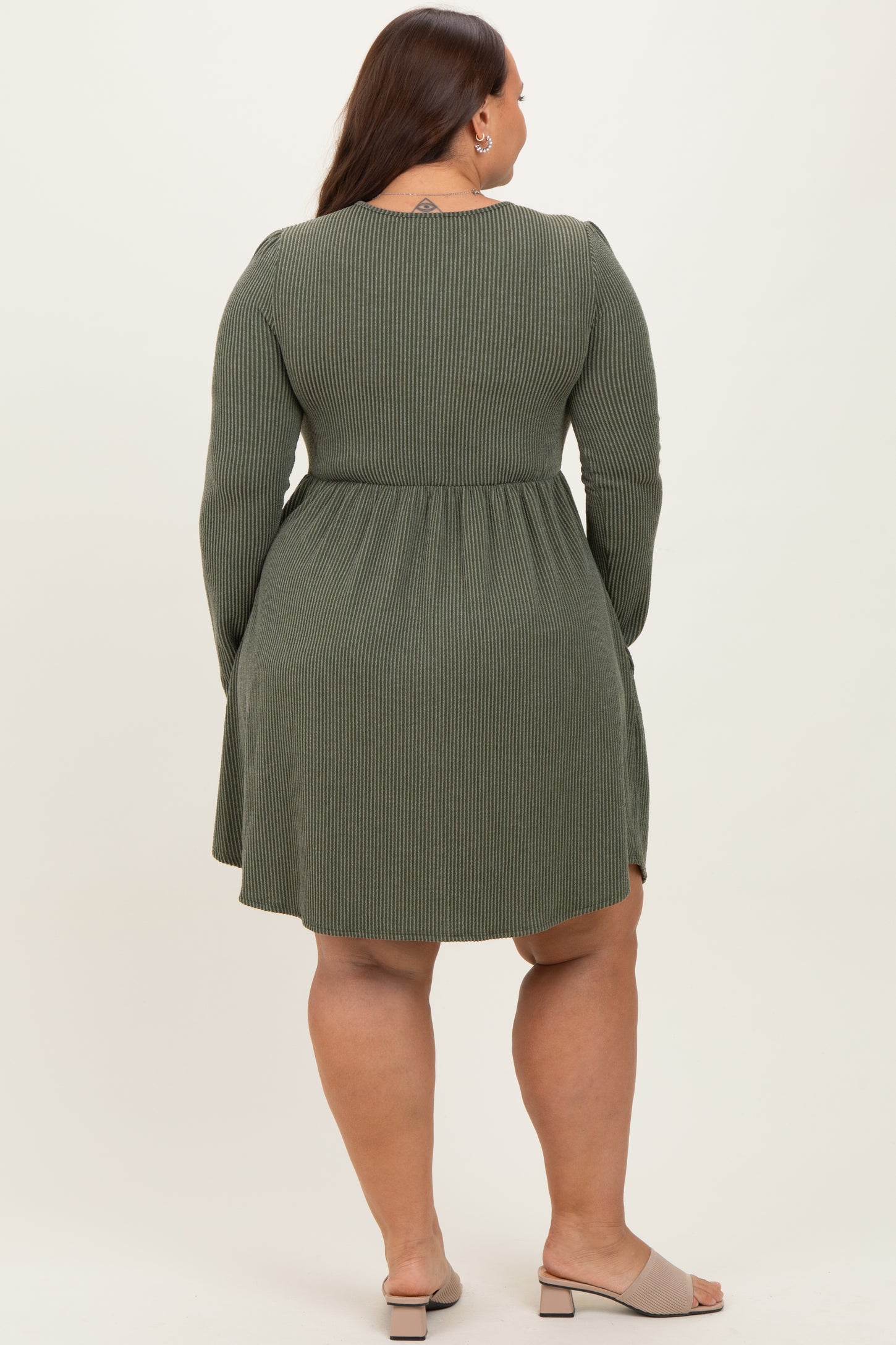 plus size woman wearing a long sleeve olive green ribbed dress with a fitted waist and flared skirt