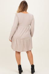 woman wearing a taupe maternity plus long sleeve dress with a tiered hem and a rounded neckline, showing a relaxed fit at the back