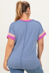 woman wearing a blue and pink striped maternity plus top from the back, featuring short sleeves and a relaxed fit