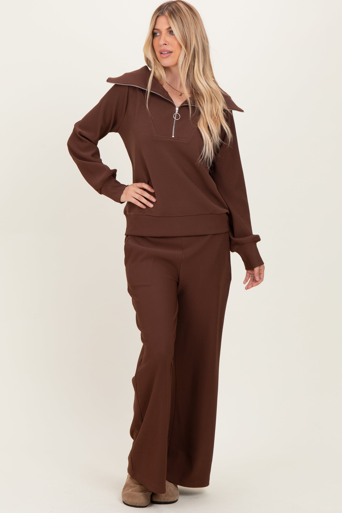 woman wearing a brown ribbed zip-up top with oversized collar and matching wide-leg pants