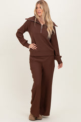 woman wearing a brown ribbed zip-up top with oversized collar and matching wide-leg pants