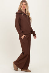woman wearing a brown ribbed lounge set with a zip-up hoodie and wide-leg pants, styled with cozy footwear