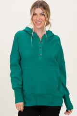 woman wearing a green hoodie with buttons and a relaxed fit