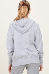 woman wearing a gray oversized maternity hoodie with a hood, seen from the back