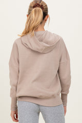 woman wearing a beige maternity hoodie with a relaxed fit and back hood detail