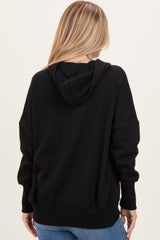 woman wearing a black oversized hoodie viewed from the back, styled with casual blue jeans