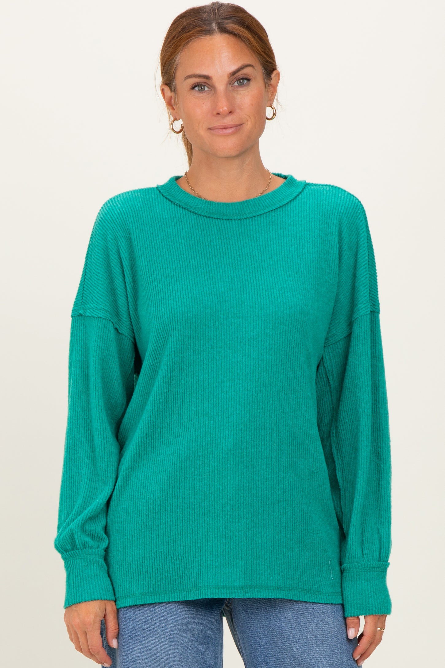 woman wearing a teal oversized ribbed long sleeve sweater with a round neckline and relaxed fit