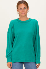 woman wearing a teal oversized ribbed long sleeve sweater with a round neckline and relaxed fit