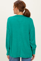woman wearing a green oversized ribbed sweater with a back seam detail and long sleeves