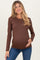 woman wearing a brown long sleeve maternity top and holding her baby bump