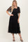 woman wearing a black tiered midi dress with puff sleeves and a square neckline, standing confidently