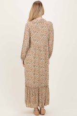 woman wearing a long floral print maxi dress with long sleeves and a tiered skirt, viewed from the back