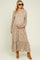 woman wearing a floral long sleeve maternity maxi dress and cradling her baby bump