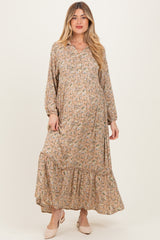 woman wearing a floral maternity dress with long sleeves and a tiered hem, showcasing her baby bump