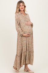 woman wearing a floral maternity dress with a tiered skirt and holding her baby bump