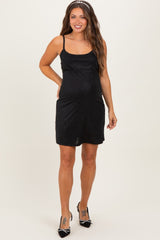 woman wearing a black sparkly maternity dress with spaghetti straps and a visible baby bump